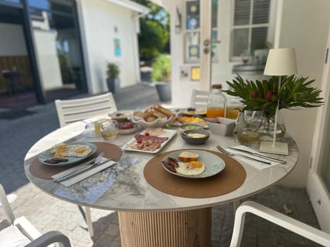 Breakfast laid out on the terrace — eggs, cold meats, cheeses, breads and juice